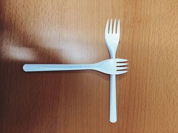 Directly above shot of plastic forks on wooden table