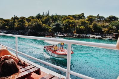 People swimming in pool by sea against clear sky