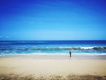 Scenic view of beach against blue sky