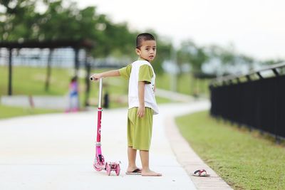 Portrait of cute boy standing on footpath