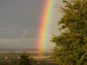 Scenic view of rainbow over landscape against sky