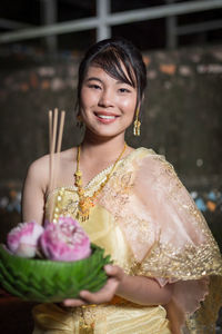 Portrait of smiling young woman sitting on table