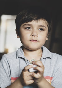 Close-up of cute boy looking away at home