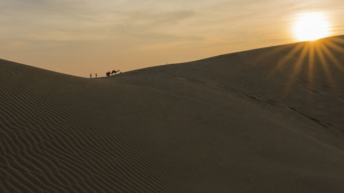 Scenic view of desert against sky during sunset