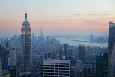 Skyscrapers in city at sunset