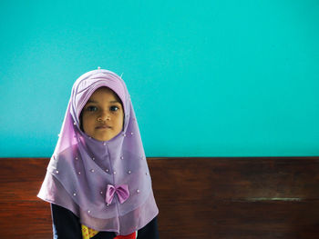 Portrait of girl standing against pink wall