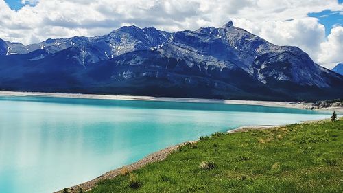 Scenic view of lake by mountains against sky