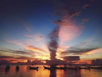 Silhouette boats in sea against sky during sunset