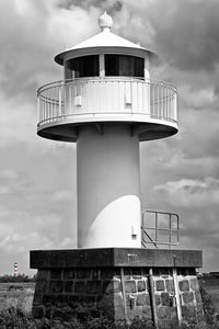 Lighthouse by sea against sky