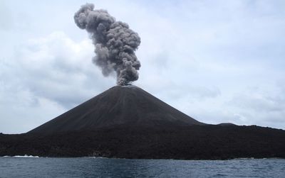 Low angle view of volcanic mountain against sky