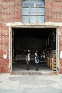Two businessmen talking at an old storehouse