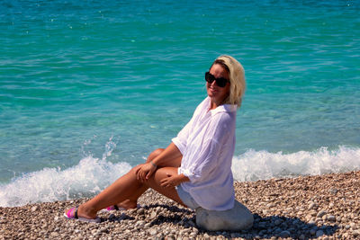 Full length of woman sitting on beach