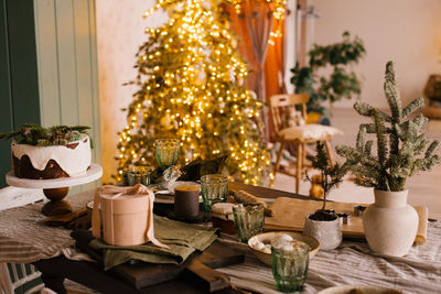 Festive table set for christmas dinner on the background of tree and lights