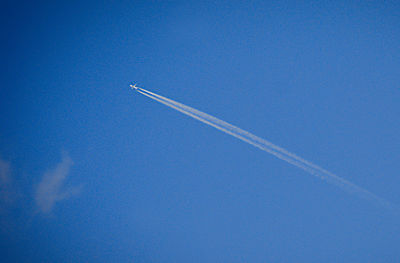 Low angle view of vapor trail against blue sky