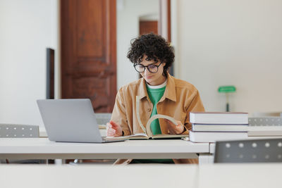 Doctor using laptop at desk in office