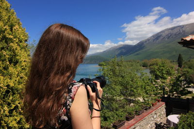 Rear view of woman against blue sky