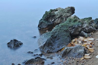 Rocks in sea against sky