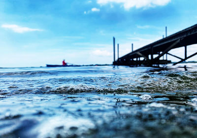 Surface level of bridge over sea against sky