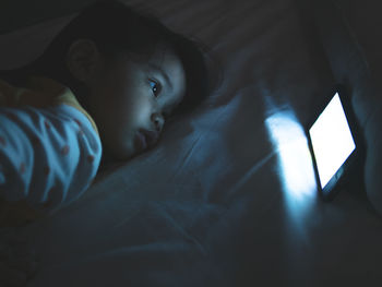 Portrait of boy lying on bed at home