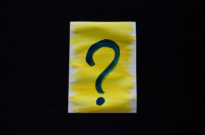 Close-up of sign on table against black background