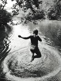 Rear view of man jumping in water