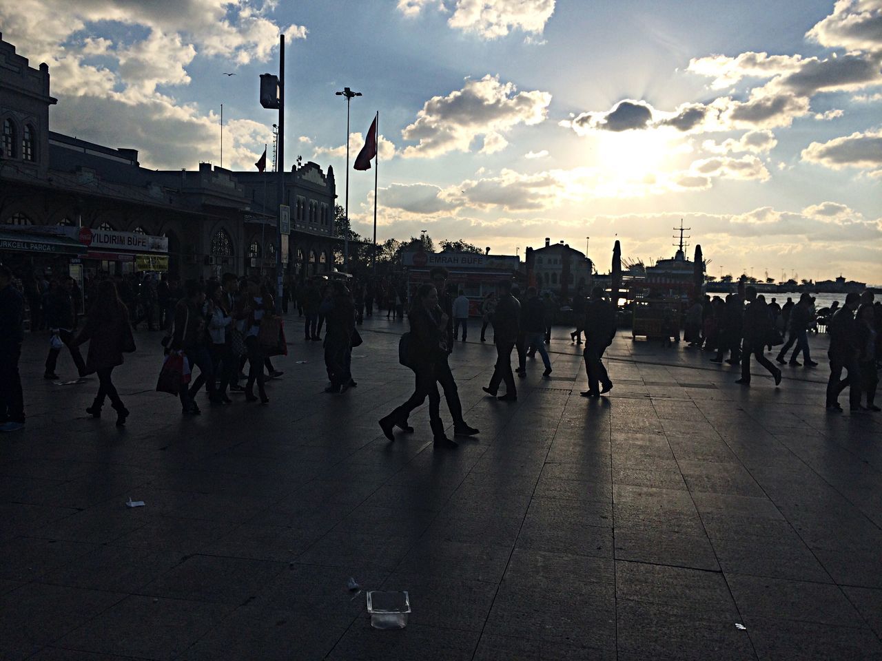 large group of people, sky, cloud - sky, men, person, building exterior, architecture, built structure, lifestyles, cloud, street, city, mixed age range, city life, walking, sunset, leisure activity, sunlight, cloudy