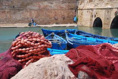 Fishing net by boats moored at harbor