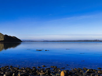 Scenic view of sea against blue sky