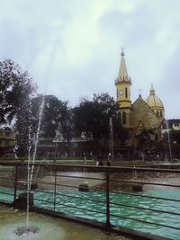 Fountain in front of temple against sky