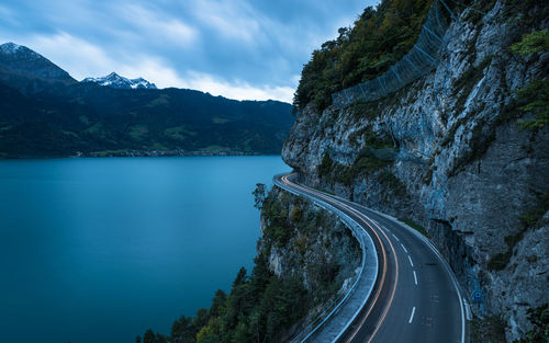 Scenic view of road by mountains against sky