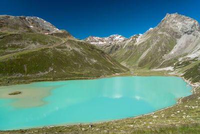 Panoramic view of lake and mountains against blue sky