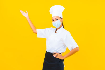 Mid section of man standing against yellow background