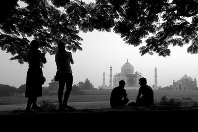 Silhouette of tourists against buildings
