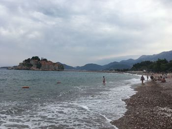 People on beach against sky