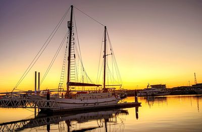 Sailboats in sea at sunset