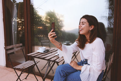 Young woman using mobile phone at home