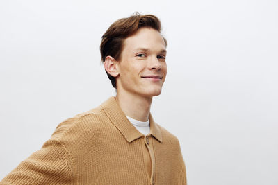 Portrait of young man standing against white background