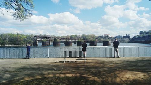 People on bridge against sky