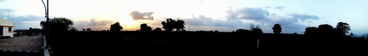 Panoramic view of silhouette trees on road against sky