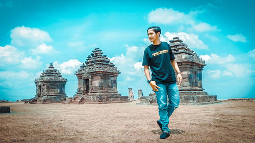 Full length of young man standing against sky