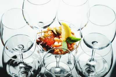 High angle view of fruits in plate by glasses on table