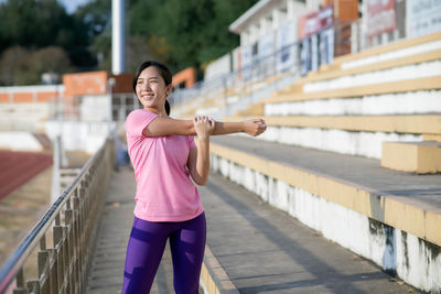 Cheerful young woman exercising outdoors