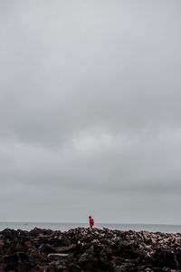 Mid distance on man on landscape against cloudy sky