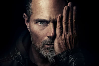 Portrait of man against black background