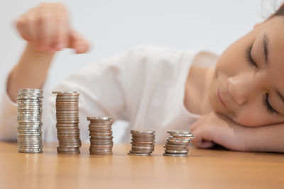 Cropped hand of woman holding coins on table