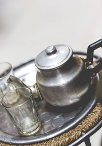 High angle view of teapot with glasses on plate