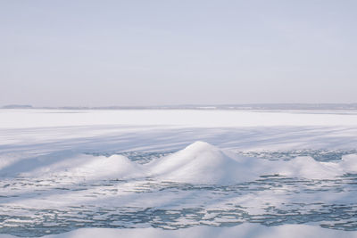 Frozen lake with snow in sunny winter day.