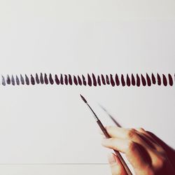 Close-up of hand painting with brush on whiteboard