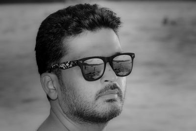 Close-up portrait of young man wearing sunglasses