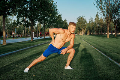 Full length of man exercising on field